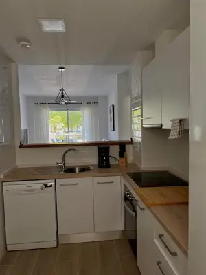 a kitchen with white cabinets and a sink and a window at Apartamento en Costa Ballena in Chipiona