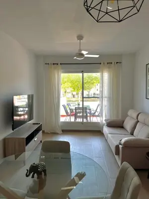 a living room with a couch and a glass table at Apartamento en Costa Ballena in Chipiona