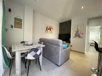 a living room with a table and a couch at Playa La Barrosa, AlojamientosLola in Chiclana de la Frontera