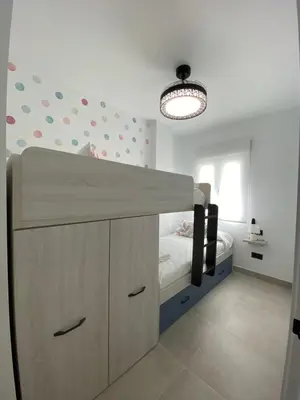 a bedroom with a bunk bed and a light fixture at Playa La Barrosa, AlojamientosLola in Chiclana de la Frontera
