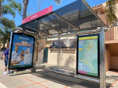 a bus stop with two signs in front of it at Playa La Barrosa, AlojamientosLola in Chiclana de la Frontera