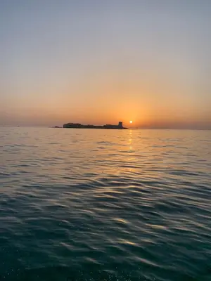 a sunset over a large body of water at Playa La Barrosa, AlojamientosLola in Chiclana de la Frontera