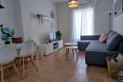a living room with a blue couch and a table at Precioso apartamento en Rota in Rota