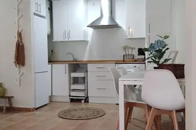 a kitchen with white cabinets and a table and chairs at Precioso apartamento en Rota in Rota
