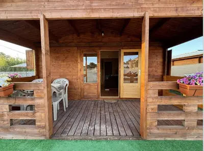 a wooden cabin with a deck with a table and chairs at Bungalow Luna in Chiclana de la Frontera