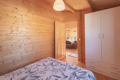 a bedroom with a bed in a wooden room at Bungalow Luna in Chiclana de la Frontera