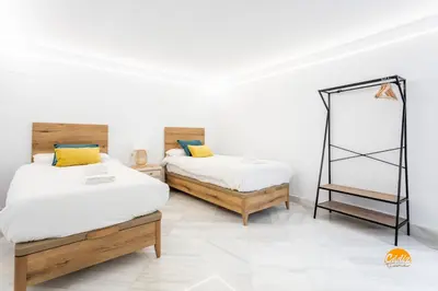 a room with two beds and a mirror in it at Casa Amanecer by Cádiz Time in Cádiz