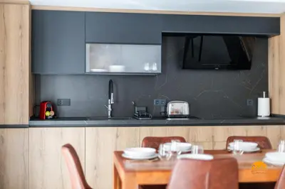 a kitchen with a wooden table with chairs and a dining room at Casa Amanecer by Cádiz Time in Cádiz