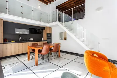 an open kitchen and dining room with a wooden table and chairs at Casa Amanecer by Cádiz Time in Cádiz