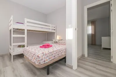 a white kitchen with white cabinets and white appliances at Poniente in Chiclana de la Frontera