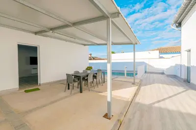 a kitchen with white cabinets and a washer and dryer at Poniente in Chiclana de la Frontera