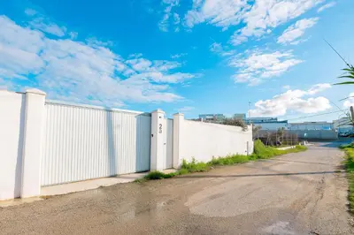 a white fence on a road with a cloudy sky at Poniente in Chiclana de la Frontera
