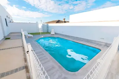 a swimming pool in front of a house at Poniente in Chiclana de la Frontera