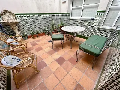 a patio with chairs and a table and a table and chairs at GATU el Capitán 