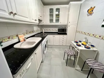 a white kitchen with a sink and a dishwasher at GATU el Capitán 