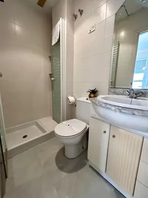 a white bathroom with a toilet and a sink at GATU el Capitán 
