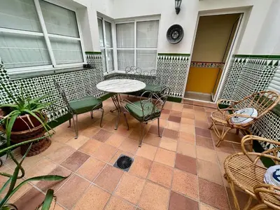 a patio with a table and chairs on a tiled floor at GATU el Capitán 