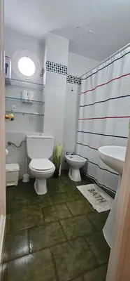 a bathroom with two toilets and a sink and an american flag at La Barrosa Beach Holiday Home By ChiclanaDreams in Chiclana de la Frontera