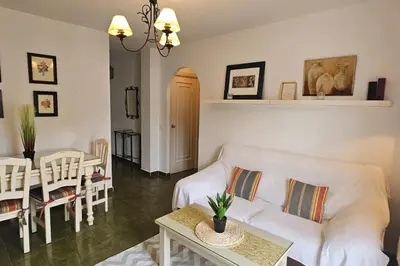 a living room with a white couch and a table at La Barrosa Beach Holiday Home By ChiclanaDreams in Chiclana de la Frontera