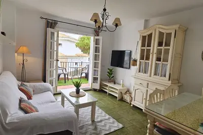a living room with a couch and a table at La Barrosa Beach Holiday Home By ChiclanaDreams in Chiclana de la Frontera