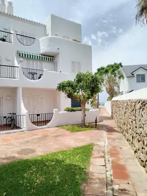 a white house with a tree in front of it at La Barrosa Beach Holiday Home By ChiclanaDreams in Chiclana de la Frontera