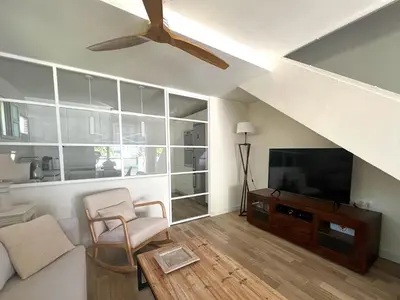 a living room with a ceiling fan and a flat screen tv at La Buganvilla in Chiclana de la Frontera