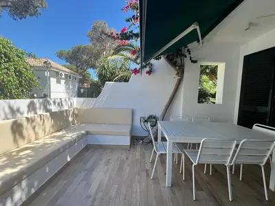 a patio with a table and chairs and a bench at La Buganvilla in Chiclana de la Frontera
