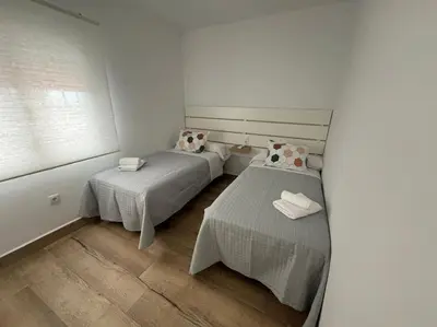 a small room with two beds and a window at El Refugio de Susana Grupo AC Gestion in Cádiz