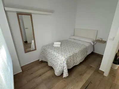 a small bedroom with a bed and a mirror at El Refugio de Susana Grupo AC Gestion in Cádiz