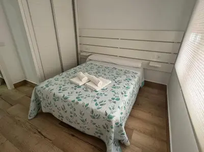 a small room with a bed with two books on it at El Refugio de Susana Grupo AC Gestion in Cádiz