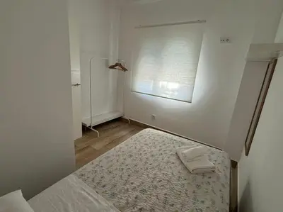 a small white room with a bed and a window at El Refugio de Susana Grupo AC Gestion in Cádiz