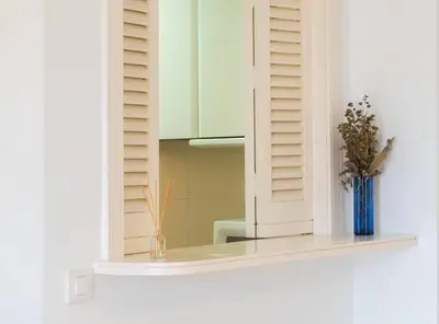 a window with a blue vase sitting on a shelf at Apartoyou - Sol y Playa Goleta in El Puerto de Santa María
