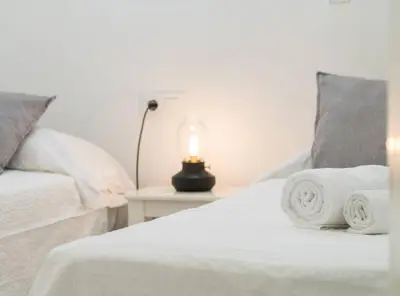 a bedroom with a bed with a lamp on a table at Apartoyou - Sol y Playa Goleta in El Puerto de Santa María