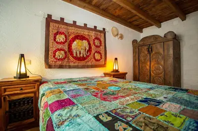 a bedroom with a bed and a tapestry on the wall at Villa Tailan con piscina y jacuzzi privado in Chiclana de la Frontera
