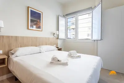 a bedroom with a large white bed with towels on it at Delfin Azul by Cadiz Time in Cádiz