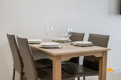 a wooden table with chairs and wine glasses on it at Delfin Azul by Cadiz Time in Cádiz