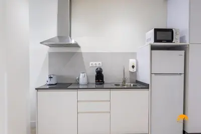 a white kitchen with a sink and a microwave at Delfin Azul by Cadiz Time in Cádiz