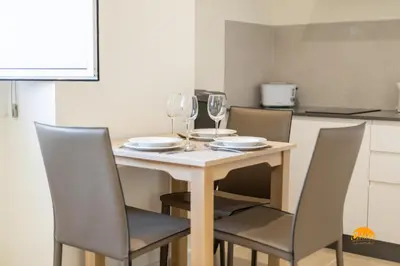 a dining room table with chairs and wine glasses at Delfin Azul by Cadiz Time in Cádiz