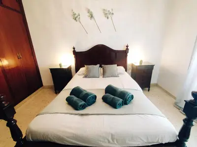 a bedroom with a bed with two green pillows on it at Casa Comodoro in Cádiz