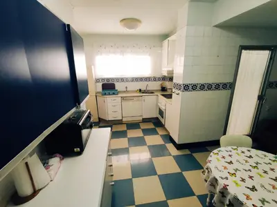 a small kitchen with a sink and a table at Casa Comodoro in Cádiz