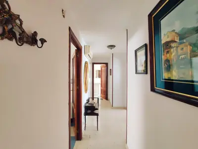 a hallway with a painting on the wall and a chair at Casa Comodoro in Cádiz