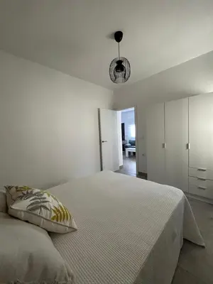 a white bedroom with a bed with a pillow at Capillita de Bajo Guía in Sanlúcar de Barrameda