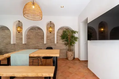 a dining room with a table and a brick wall at Apartamento Isaac Peral 2 in Chipiona