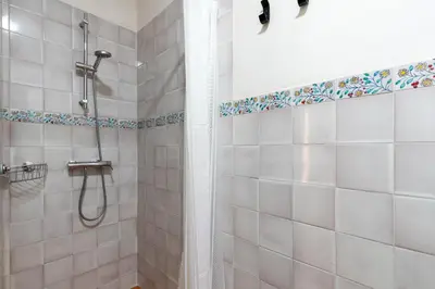 a bathroom with a shower with white tiles at Apartamento Isaac Peral 2 in Chipiona