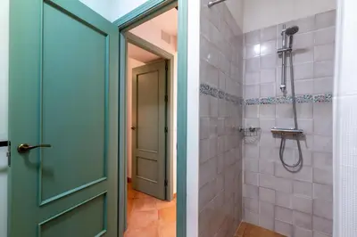 a bathroom with a shower and a green door at Apartamento Isaac Peral 2 in Chipiona