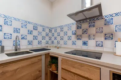 a kitchen with blue and white tiles on the wall at Apartamento Isaac Peral 2 in Chipiona