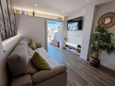 a living room with a couch and a television at Modern Beach Front Home by Chiclana Dreams in Chiclana de la Frontera