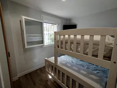 a bedroom with a bunk bed and a mirror at Modern Beach Front Home by Chiclana Dreams in Chiclana de la Frontera