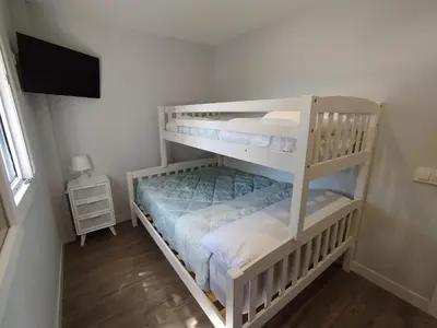 a bedroom with two bunk beds and a television at Modern Beach Front Home by Chiclana Dreams in Chiclana de la Frontera