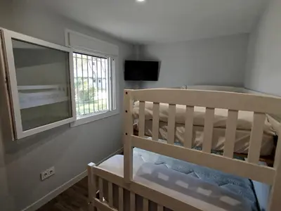 a bedroom with a bunk bed and a window at Modern Beach Front Home by Chiclana Dreams in Chiclana de la Frontera
